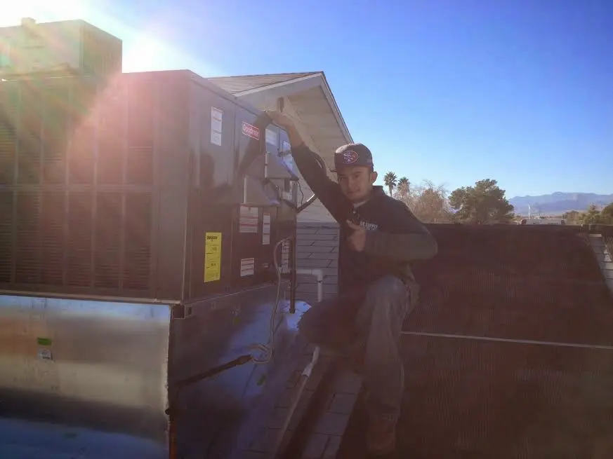 HVAC technician performing AC Tune-Up on a rooftop unit in Valdosta